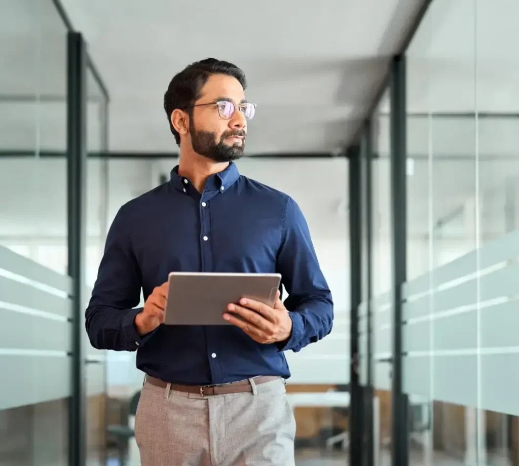 man holding a tablet computer while walking through an office