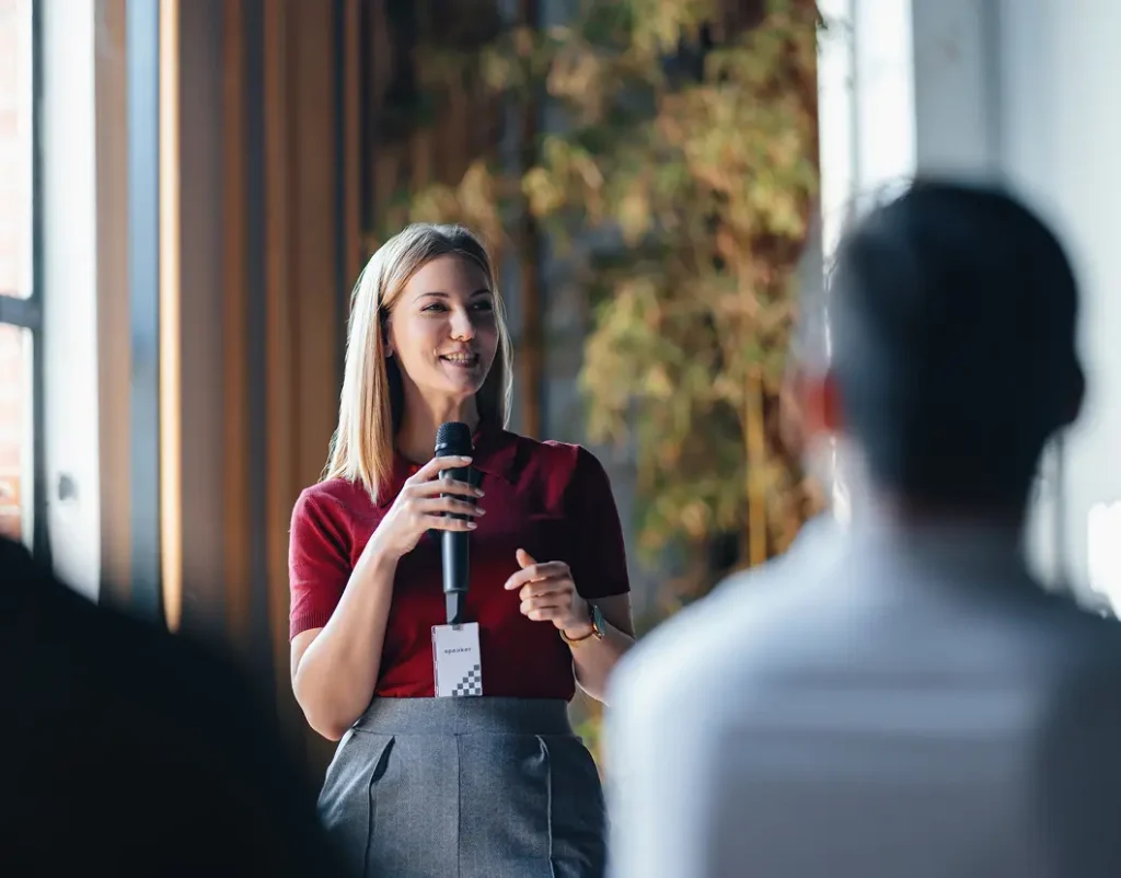 Cheerful event speaker addressing attendees at a conference.