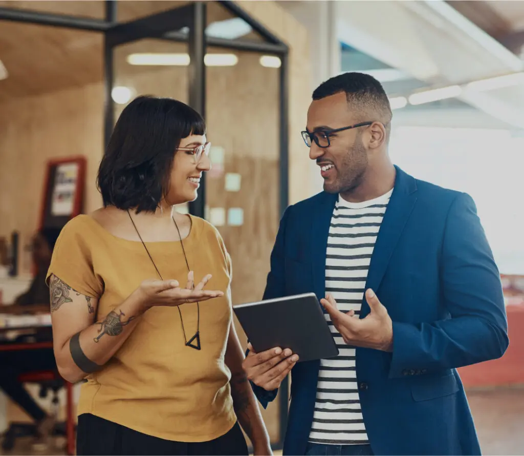 professional colleagues talking while holding a tablet computer
