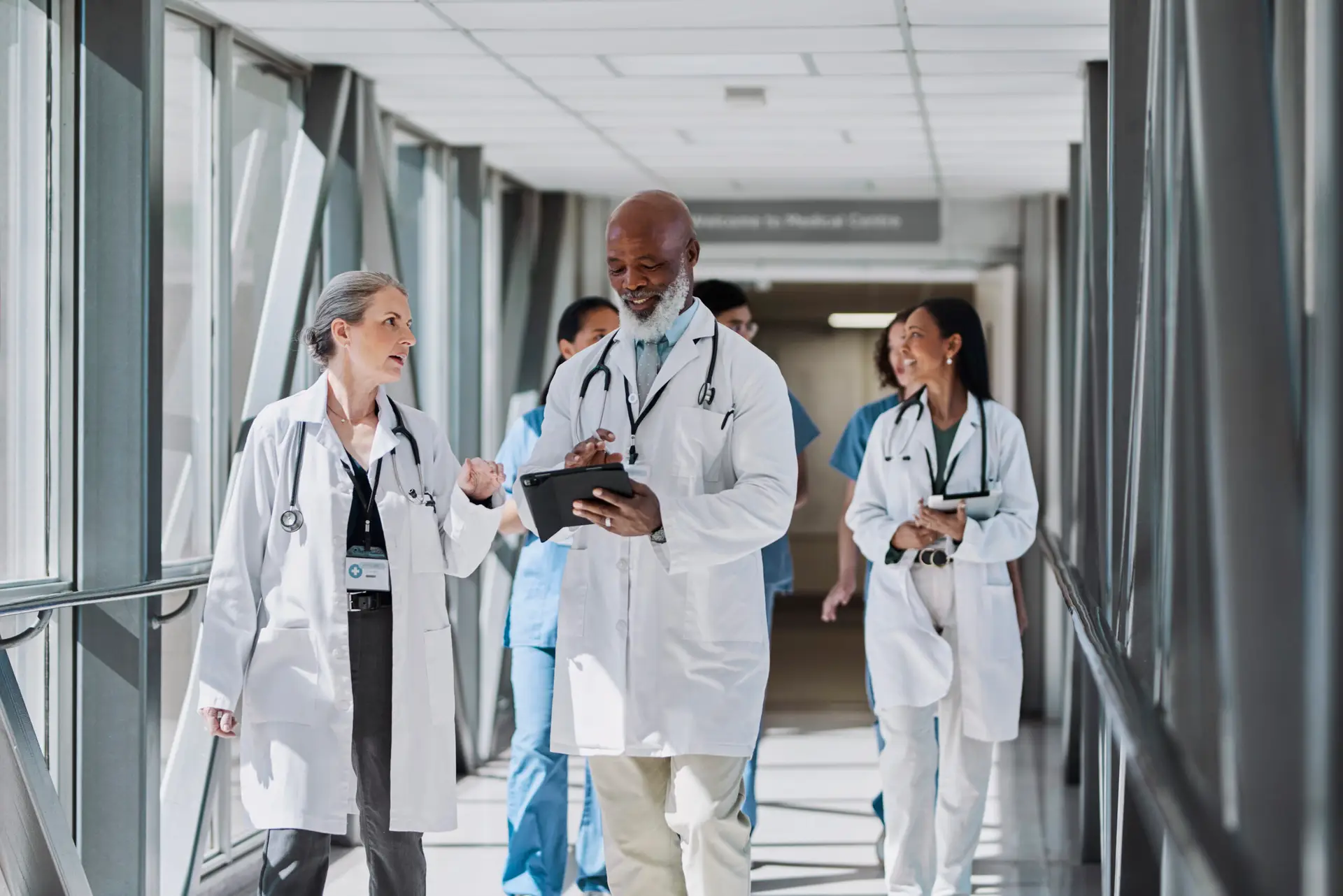Senior specialist and female doctor discussing work at hospital corridor