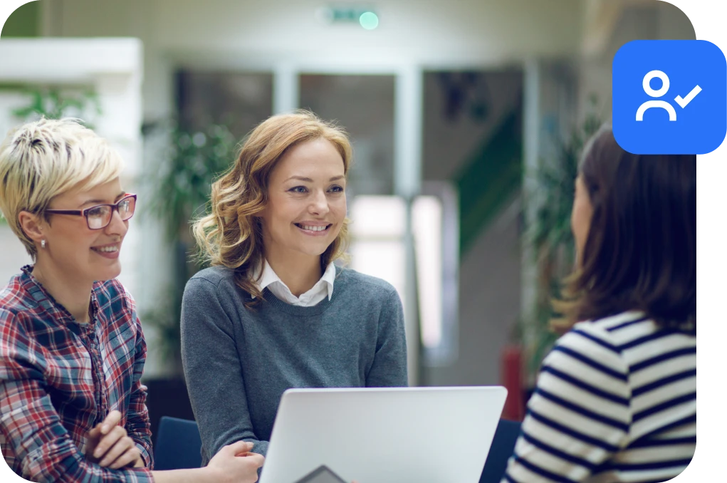 women talking around a laptop computer